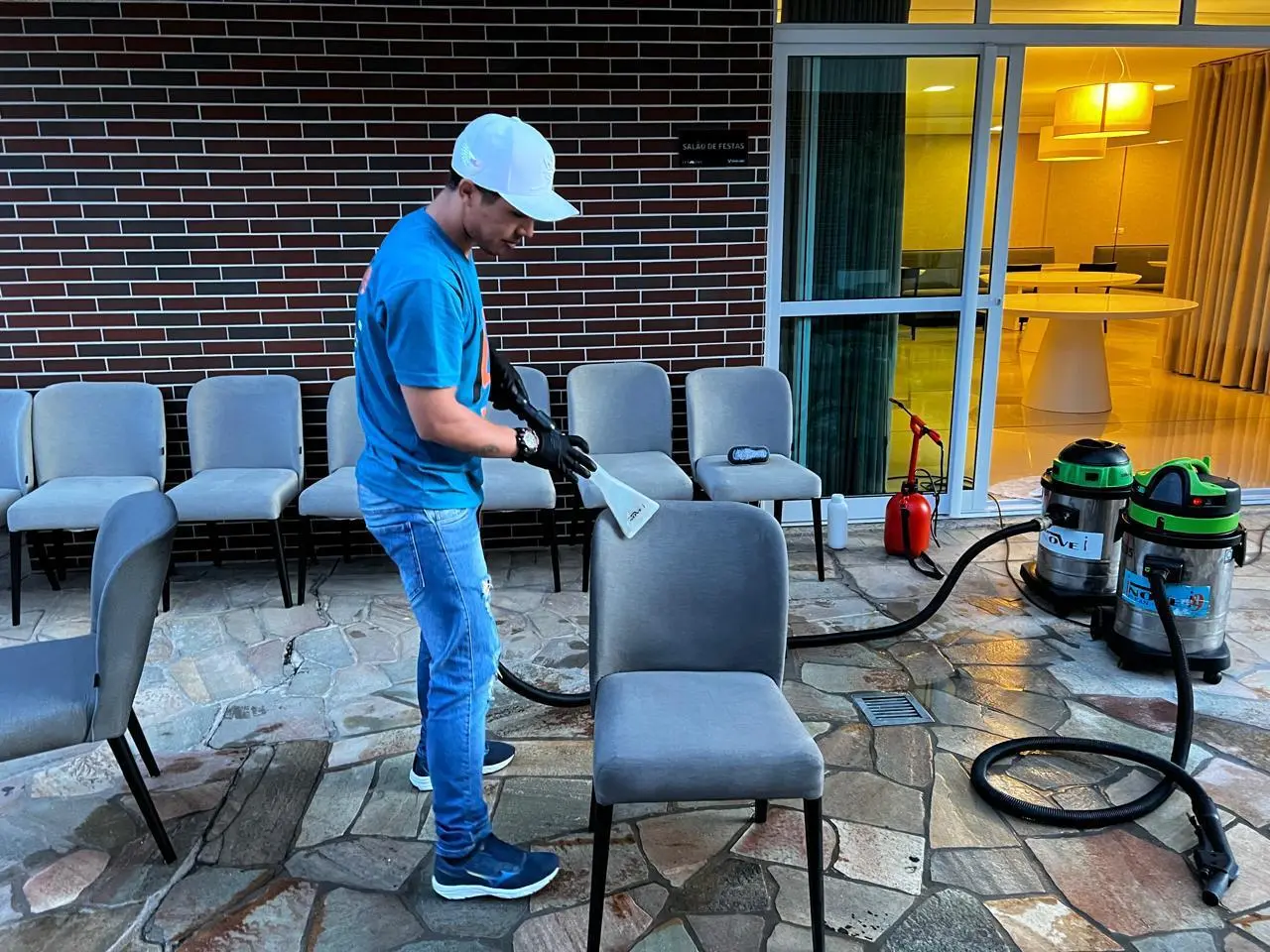 Técnico uniformizado da Inove Clean higienizando cadeiras